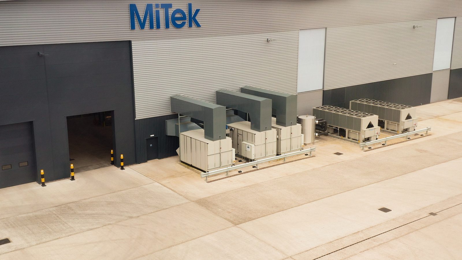 Three air handling units and two heat pumps installed outside the MiTek facility