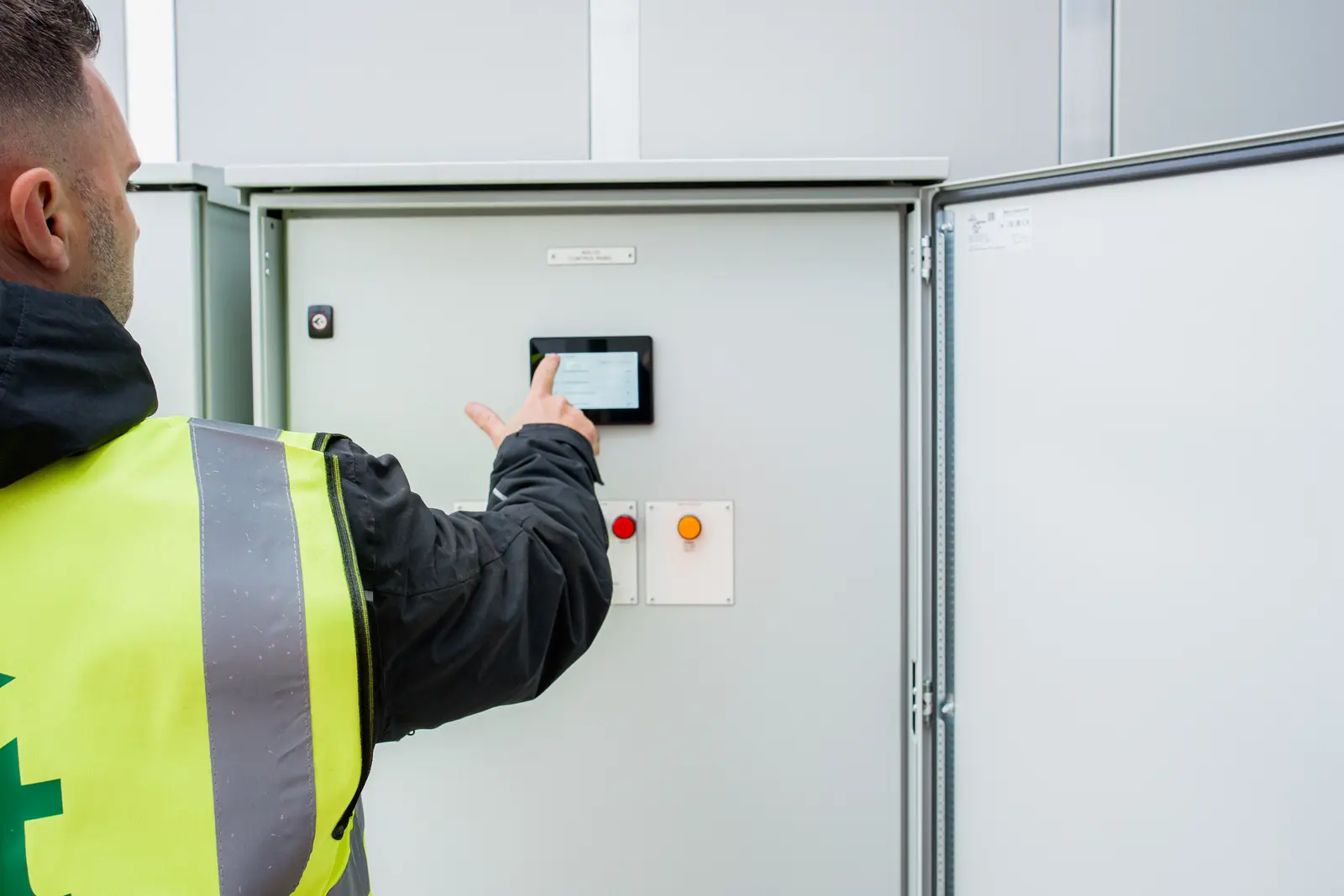 An engineer using the touchscreen on a plant control panel