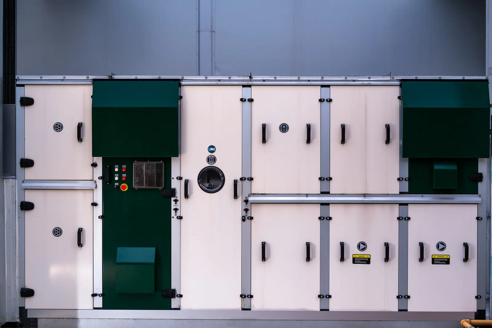 A large cream and green air handling unit with rows of hinged access doors