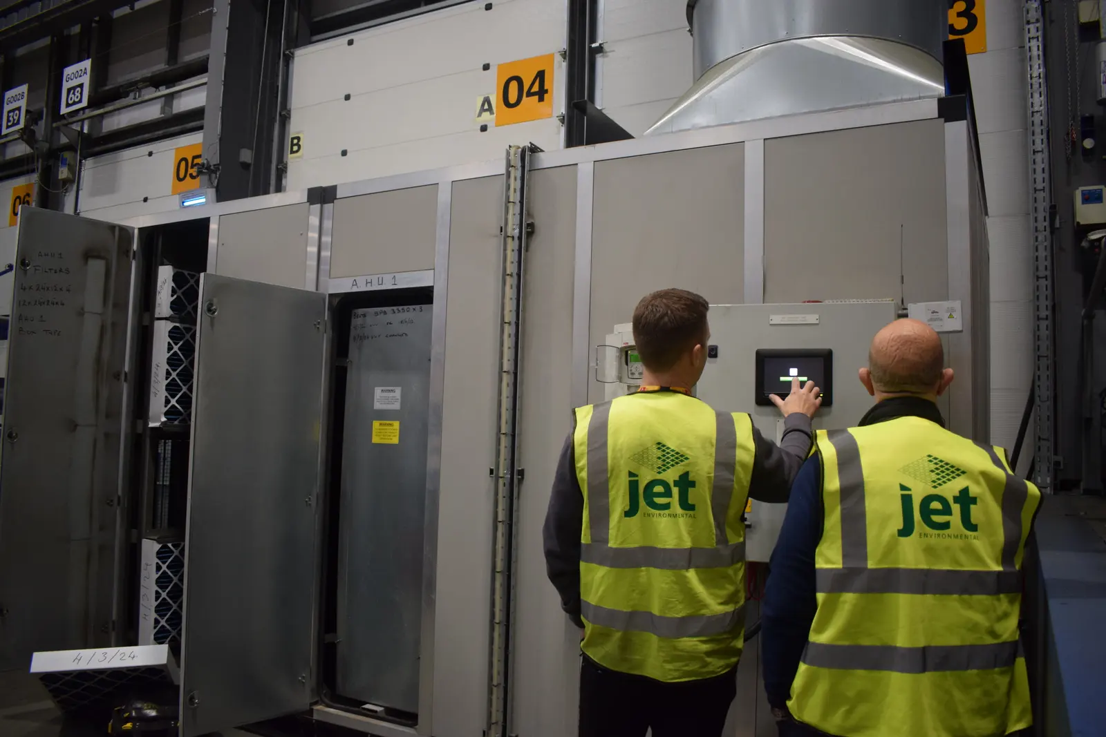 Two Jet Environmental engineers at the control panel of an air handling unit